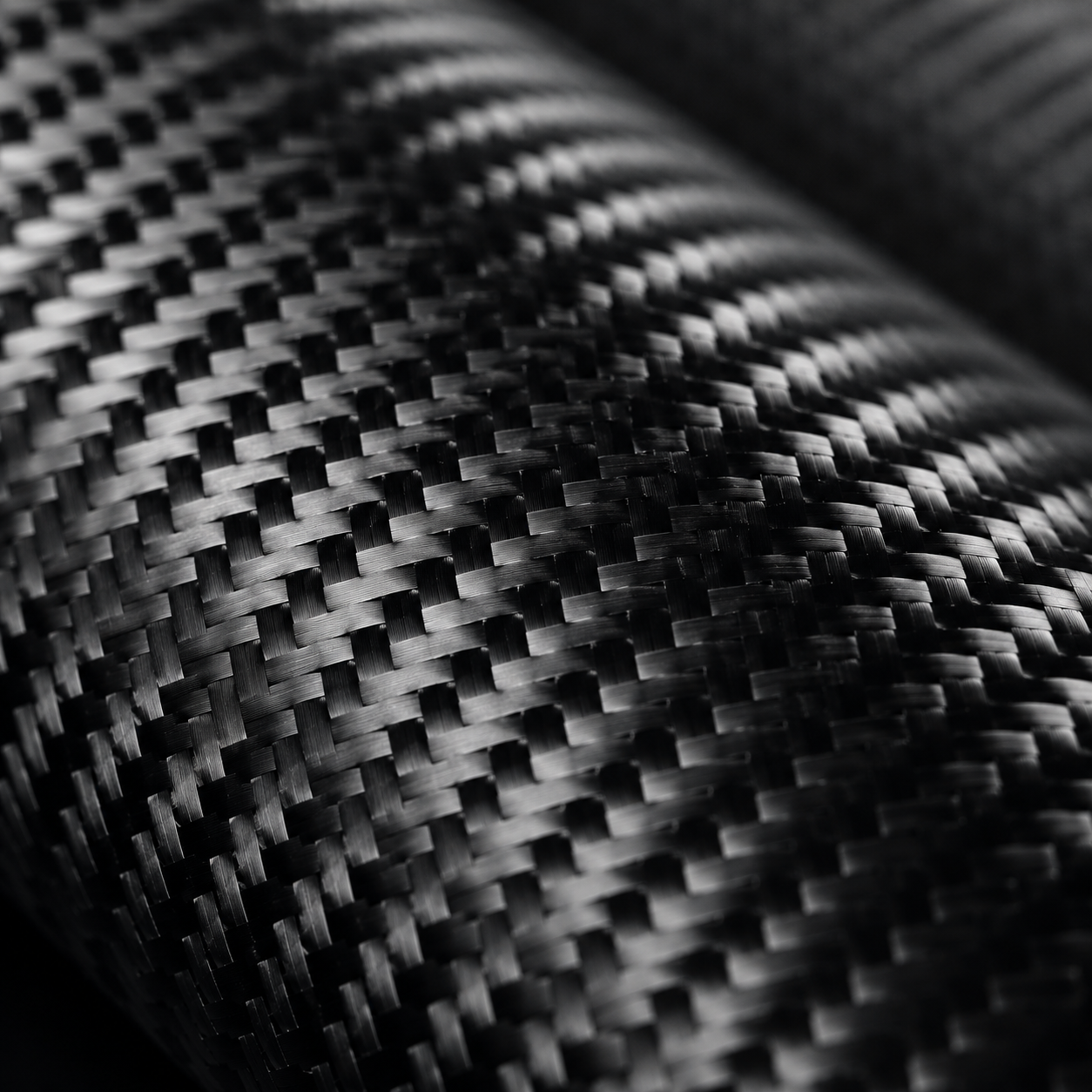 Detailed macro of woven carbon fiber, the advanced composite material used in Formula 1, luxury automotive engineering and iXOOST high-end audio speakers.