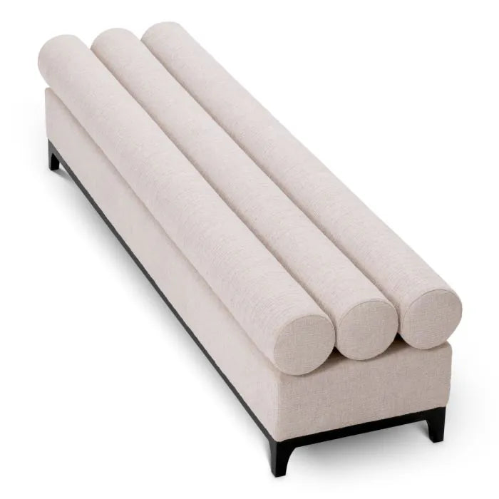 Eichholtz Bench Halbury upholstered in Alturo beige fabric with horizontal bolster cushions and sleek black metal base