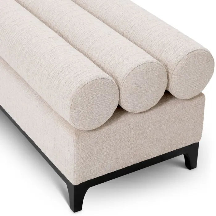 Eichholtz Bench Halbury upholstered in Alturo beige fabric with horizontal bolster cushions and sleek black metal base